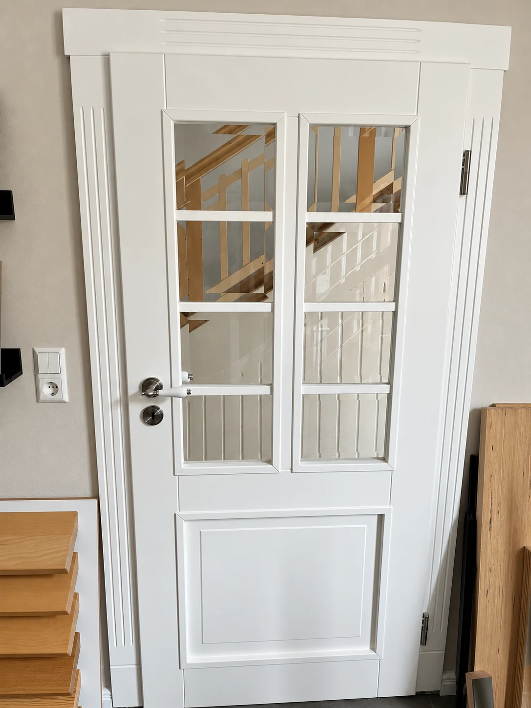 Weiße Tür mit gegliederten Glasflächen und profilierter Zarge